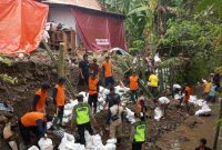 Petugas bersama warga melakukan kerja bakti membersihkan material longsor talud sungai di Dukuh Wanasara, Desa Kemangguan, Kecamatan Alian, Kabupaten Kebumen.
