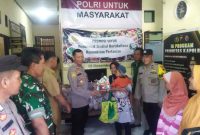 Petugas Polsek Mirit Kebumen membagikan cabai gratis kepada warga.