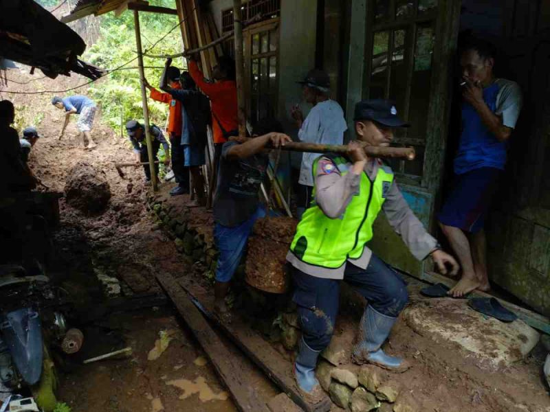 Petugas Polres Kebumen saat membantu mengevakuasi tanah longsor di rowokele.